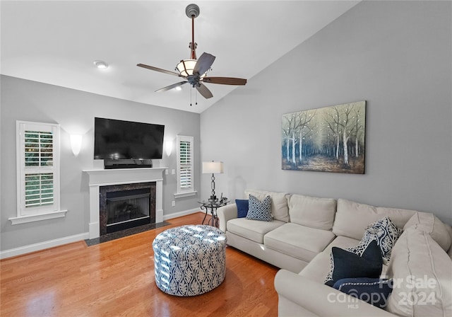 living room featuring wood-type flooring, vaulted ceiling, and ceiling fan