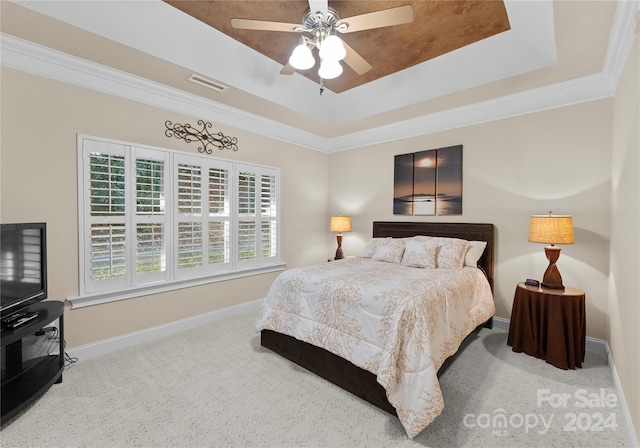 carpeted bedroom featuring a tray ceiling, ceiling fan, and ornamental molding