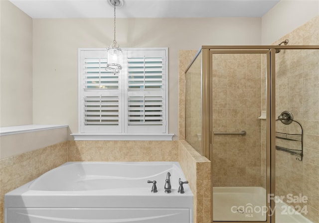 bathroom with separate shower and tub and a chandelier