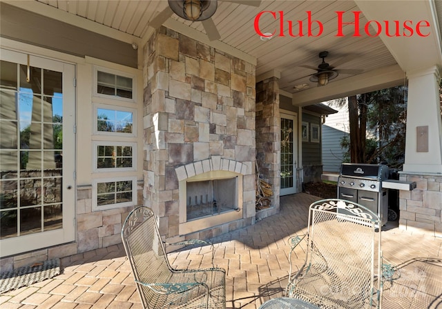 view of patio / terrace with a grill, ceiling fan, and an outdoor stone fireplace