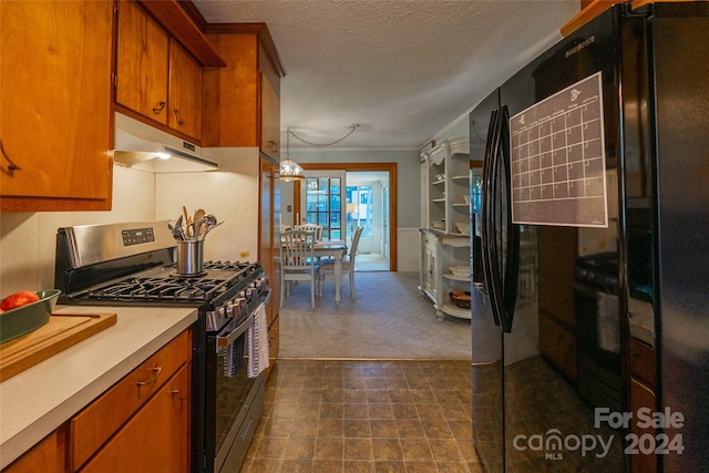 kitchen with black fridge, gas range, a textured ceiling, and crown molding