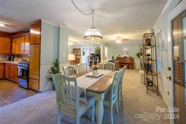 carpeted dining area featuring ceiling fan and crown molding