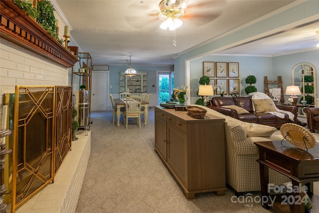 kitchen featuring a brick fireplace, light colored carpet, a textured ceiling, and crown molding