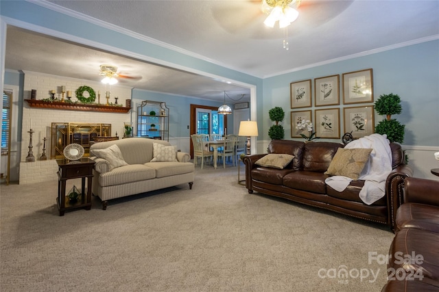 living room featuring a brick fireplace, ceiling fan, carpet flooring, and ornamental molding