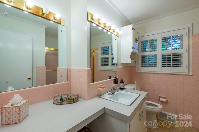 bathroom with toilet, tile walls, an enclosed shower, vanity, and crown molding