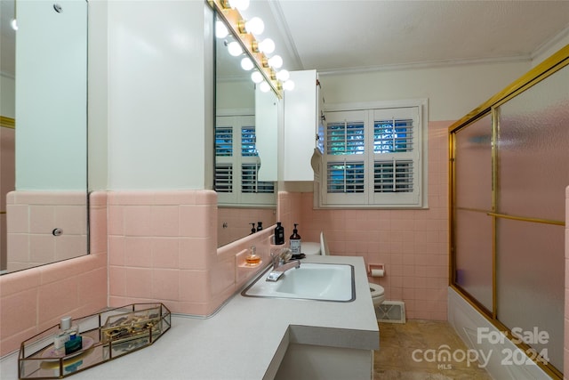 full bathroom with tile walls, tile patterned flooring, combined bath / shower with glass door, and toilet