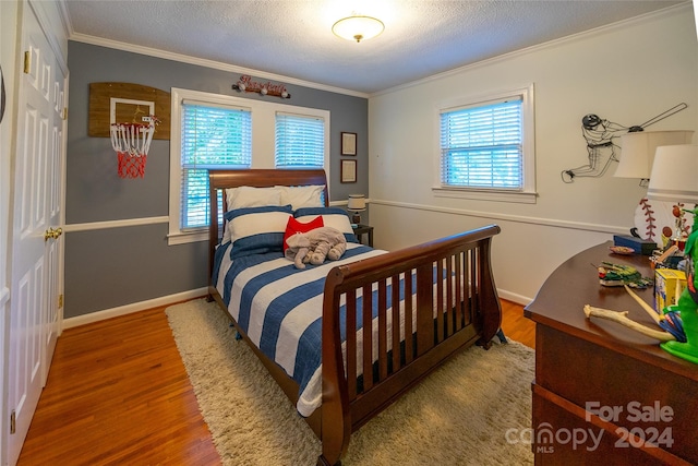 bedroom featuring hardwood / wood-style flooring, multiple windows, and crown molding