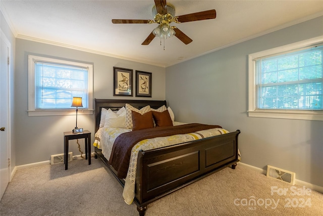 bedroom with ceiling fan, multiple windows, light carpet, and crown molding