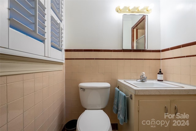 bathroom with tile walls and toilet