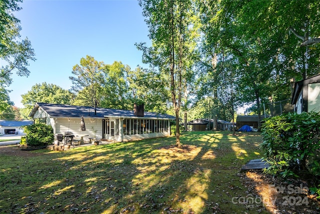 view of yard featuring a sunroom and a patio