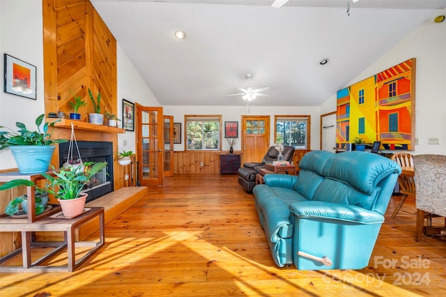 living room with ceiling fan, hardwood / wood-style flooring, and lofted ceiling