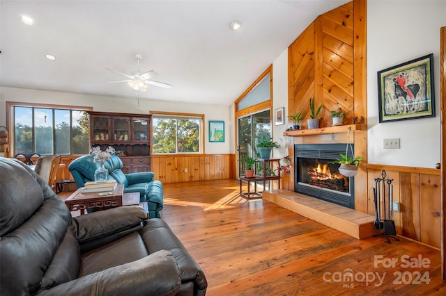 living room featuring a wealth of natural light, lofted ceiling, hardwood / wood-style flooring, and a tile fireplace