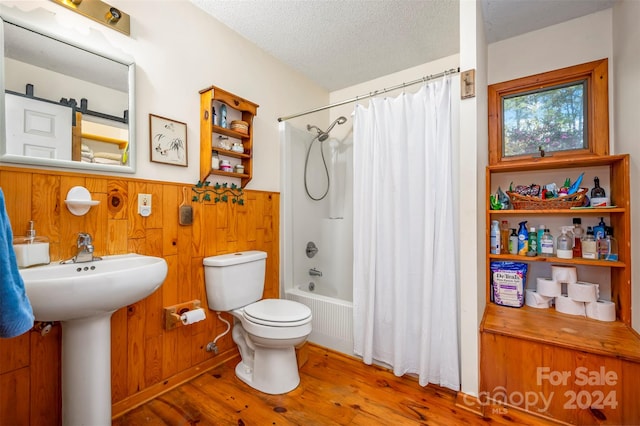 bathroom featuring toilet, wood walls, shower / tub combo with curtain, and hardwood / wood-style floors