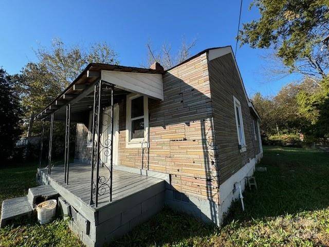 view of side of home with a yard