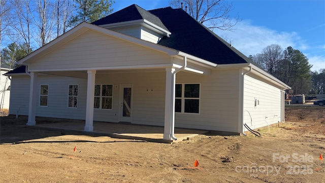 view of front of property featuring roof with shingles and a patio