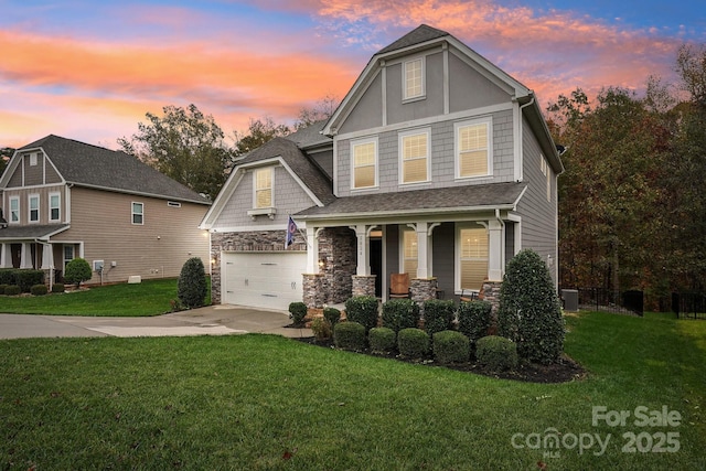 view of front of house featuring a garage, covered porch, and a lawn