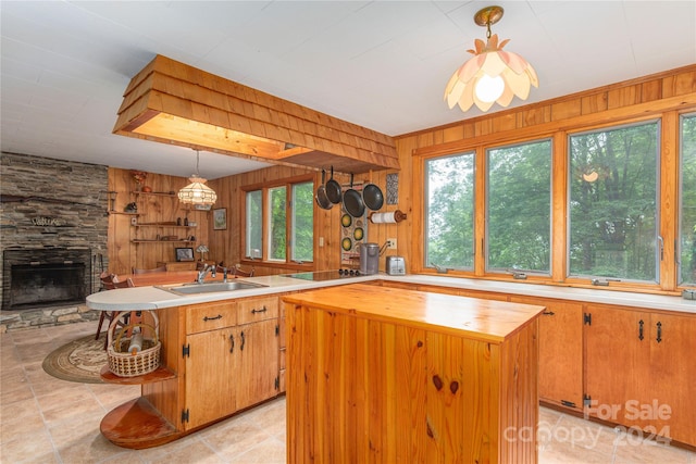 kitchen with a wealth of natural light, wooden walls, sink, and a kitchen island