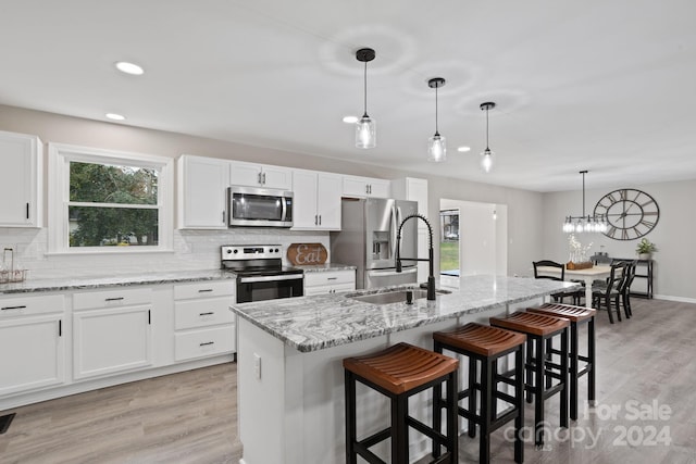 kitchen featuring appliances with stainless steel finishes, a center island with sink, and plenty of natural light