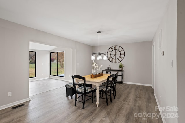 dining space with a notable chandelier and hardwood / wood-style flooring