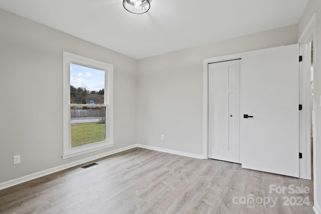 unfurnished bedroom featuring a closet and light hardwood / wood-style floors