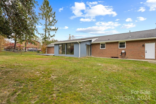 rear view of house featuring a yard