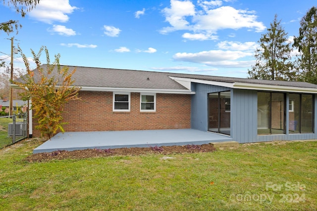 rear view of house with a patio area, a lawn, and central AC unit