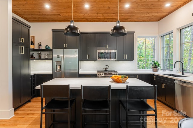 kitchen with sink, appliances with stainless steel finishes, a center island, and wooden ceiling