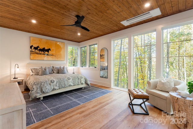 bedroom featuring multiple windows, hardwood / wood-style flooring, wooden ceiling, and ceiling fan