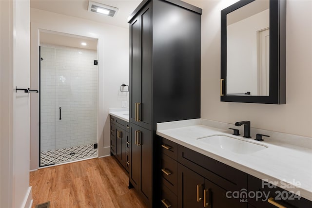 bathroom with vanity, a shower with door, and hardwood / wood-style floors