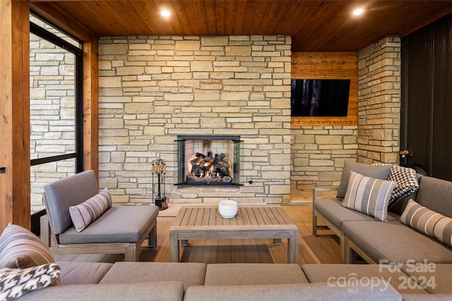 living room with hardwood / wood-style floors, wooden ceiling, and a fireplace