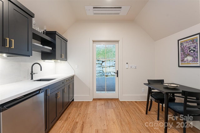 kitchen featuring stainless steel dishwasher, sink, vaulted ceiling, and light hardwood / wood-style floors