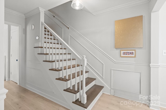 staircase featuring hardwood / wood-style floors and ornamental molding