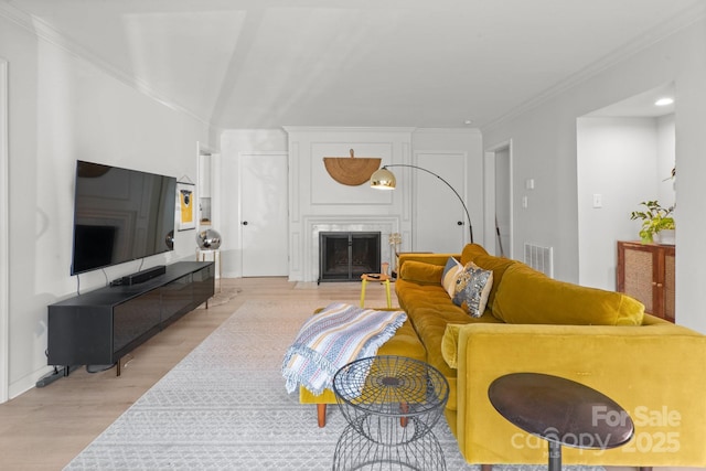 living room with light hardwood / wood-style floors and crown molding