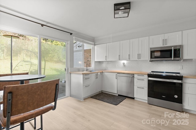 kitchen featuring backsplash, white cabinets, and appliances with stainless steel finishes