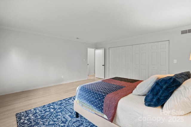 bedroom with wood-type flooring, a closet, and ornamental molding