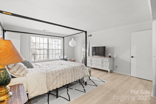 bedroom with light wood-type flooring and ornamental molding