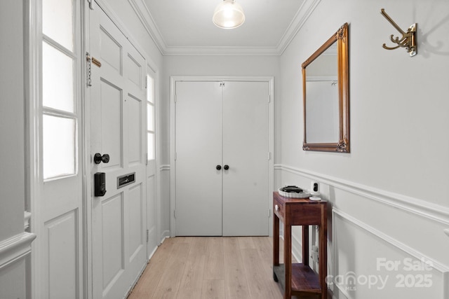 doorway to outside featuring light wood-type flooring, plenty of natural light, and ornamental molding