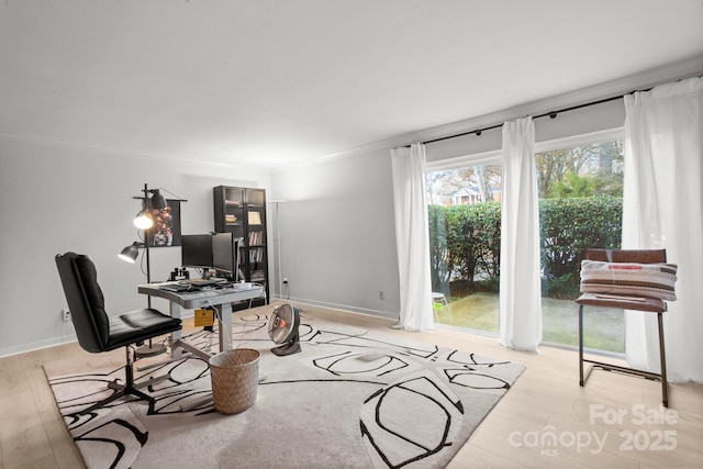 home office featuring light wood-type flooring and ornamental molding