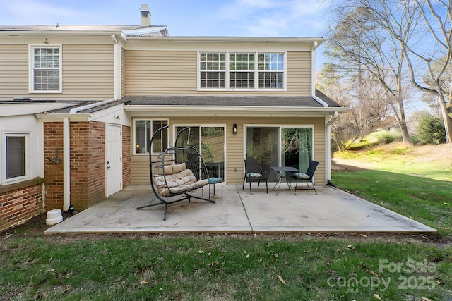 back of property with a patio area and a lawn