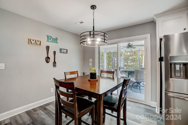 dining space with dark hardwood / wood-style flooring and ceiling fan with notable chandelier