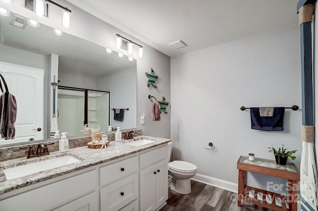 bathroom featuring hardwood / wood-style floors, vanity, toilet, and a shower with shower door