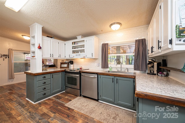 kitchen with stainless steel appliances, dark hardwood / wood-style flooring, a textured ceiling, white cabinets, and sink