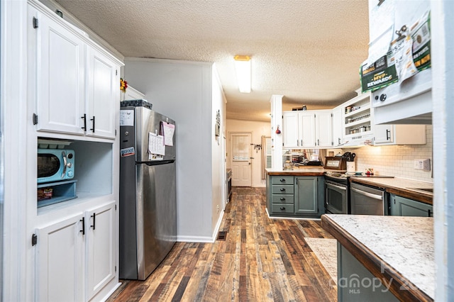 kitchen featuring a textured ceiling, appliances with stainless steel finishes, decorative backsplash, and white cabinetry