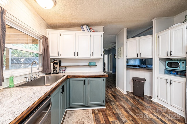 kitchen featuring a textured ceiling, white cabinetry, dark hardwood / wood-style flooring, sink, and stainless steel dishwasher