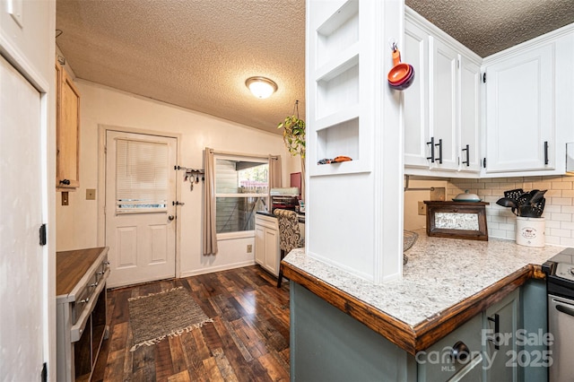 kitchen featuring lofted ceiling, decorative backsplash, a textured ceiling, white cabinets, and dark hardwood / wood-style flooring