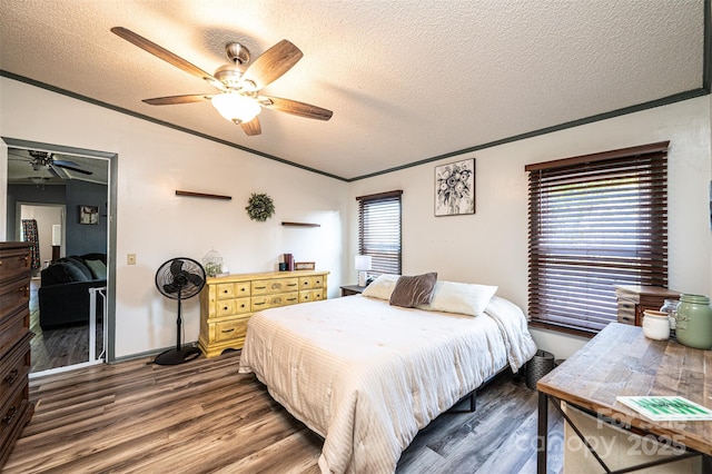 bedroom with ceiling fan, dark wood-type flooring, and a textured ceiling