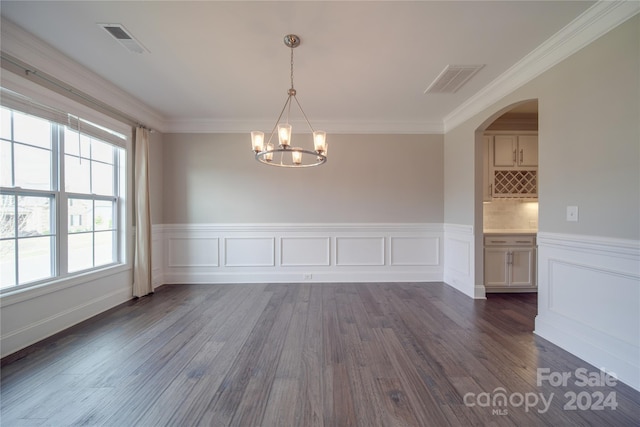 unfurnished dining area with a chandelier, dark hardwood / wood-style floors, and crown molding