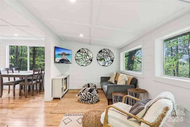 living room with light hardwood / wood-style floors and wooden walls