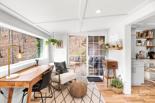 living area with vaulted ceiling with beams and light wood-type flooring