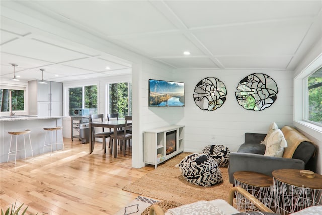 living room with coffered ceiling and light wood-type flooring